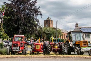 Vintage tractor rally with church in background